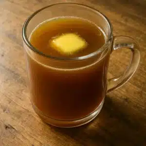 Warm apple juice prune juice and butter recipe in glass mug