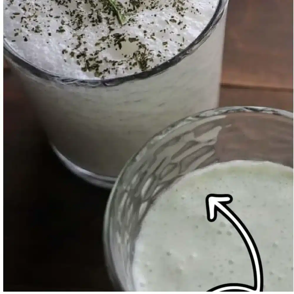 Ayran drink served in a glass with yogurt and water, garnished with mint.