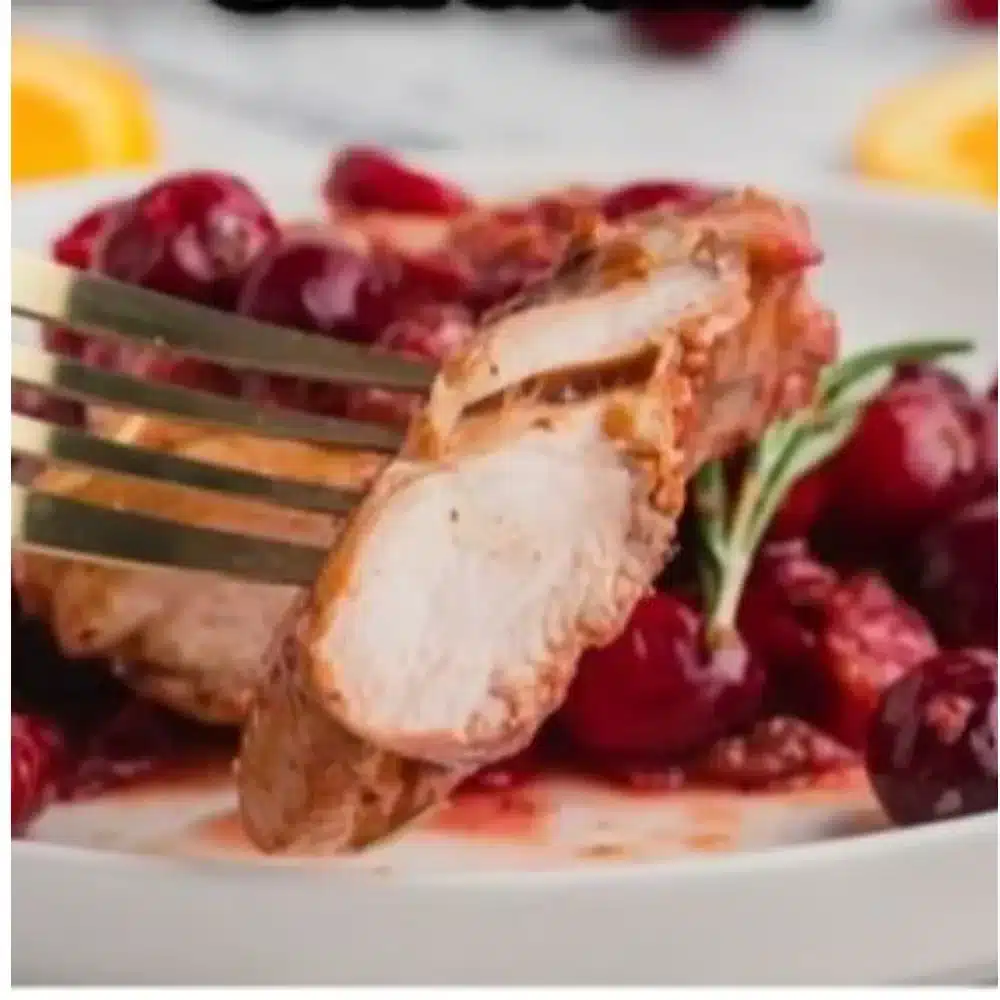 Cranberry Orange Chicken garnished with orange slices and herbs