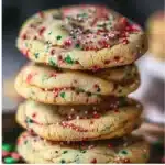 Soft Christmas sprinkle cookies decorated with colorful sprinkles on a festive plate.