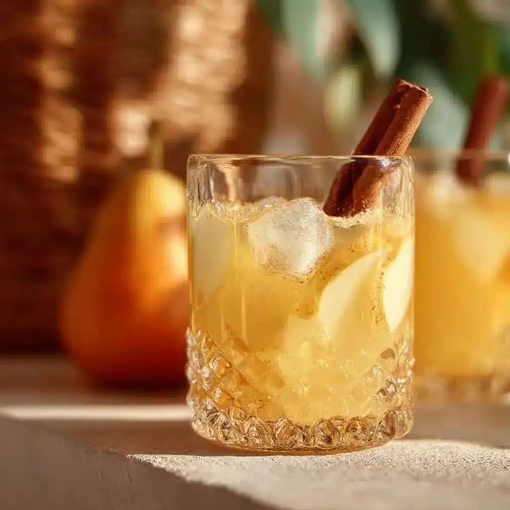 Non-alcoholic Spicy Pear Punch in a festive glass with holiday decor