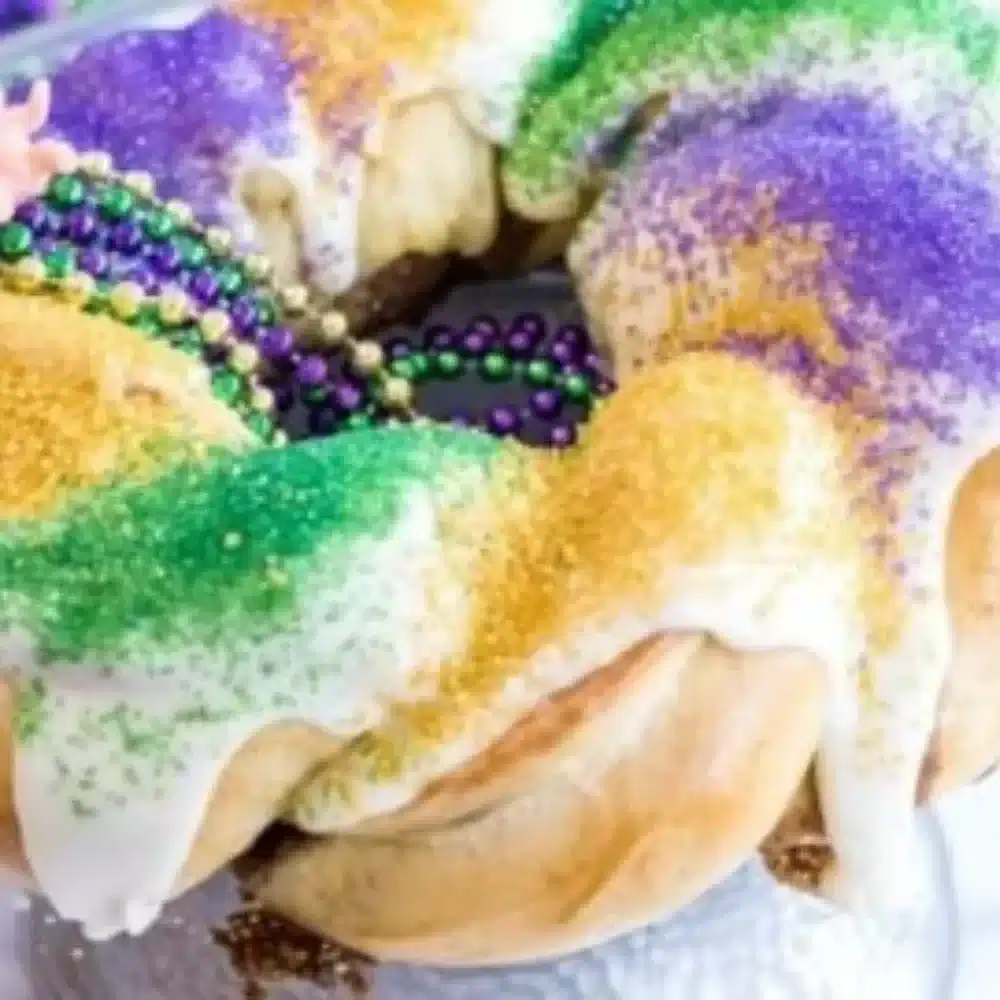 Delicious homemade king cake ready for Mardi Gras celebration with vibrant toppings.