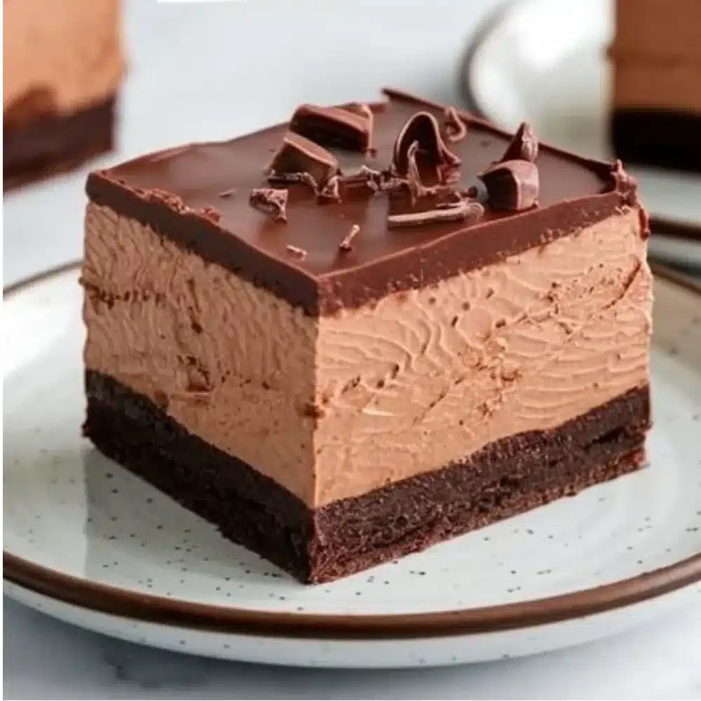 Decadent Chocolate Mousse Brownies topped with rich chocolate sauce and whipped cream