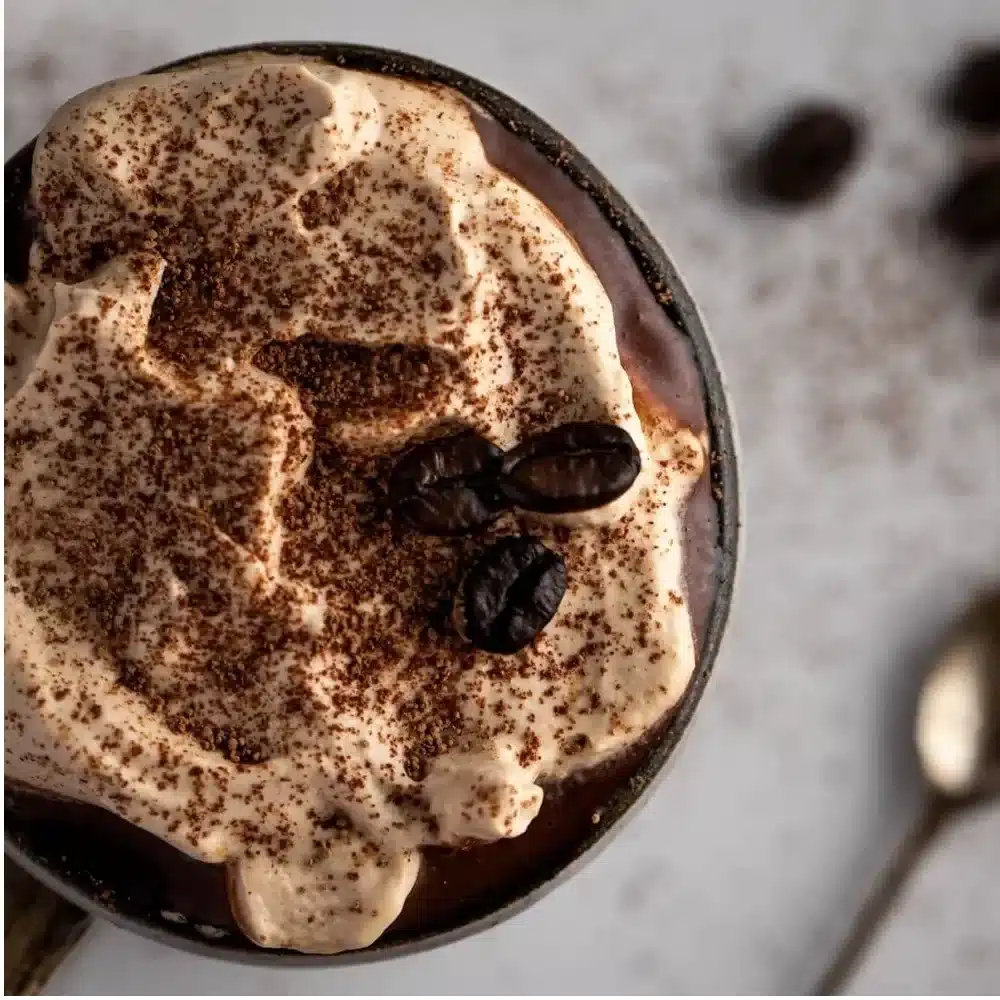 Delicious mug of Coffee Hot Chocolate topped with whipped cream and chocolate shavings