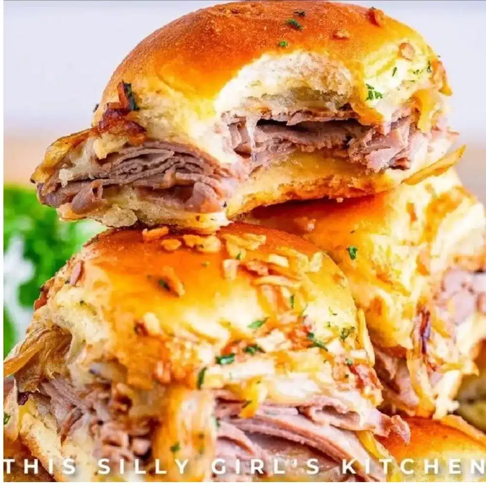 French dip sliders served on a platter with au jus for dipping