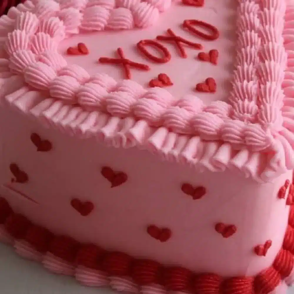 A beautifully decorated Galentine's Day Cake featuring pink frosting and heart-shaped sprinkles.