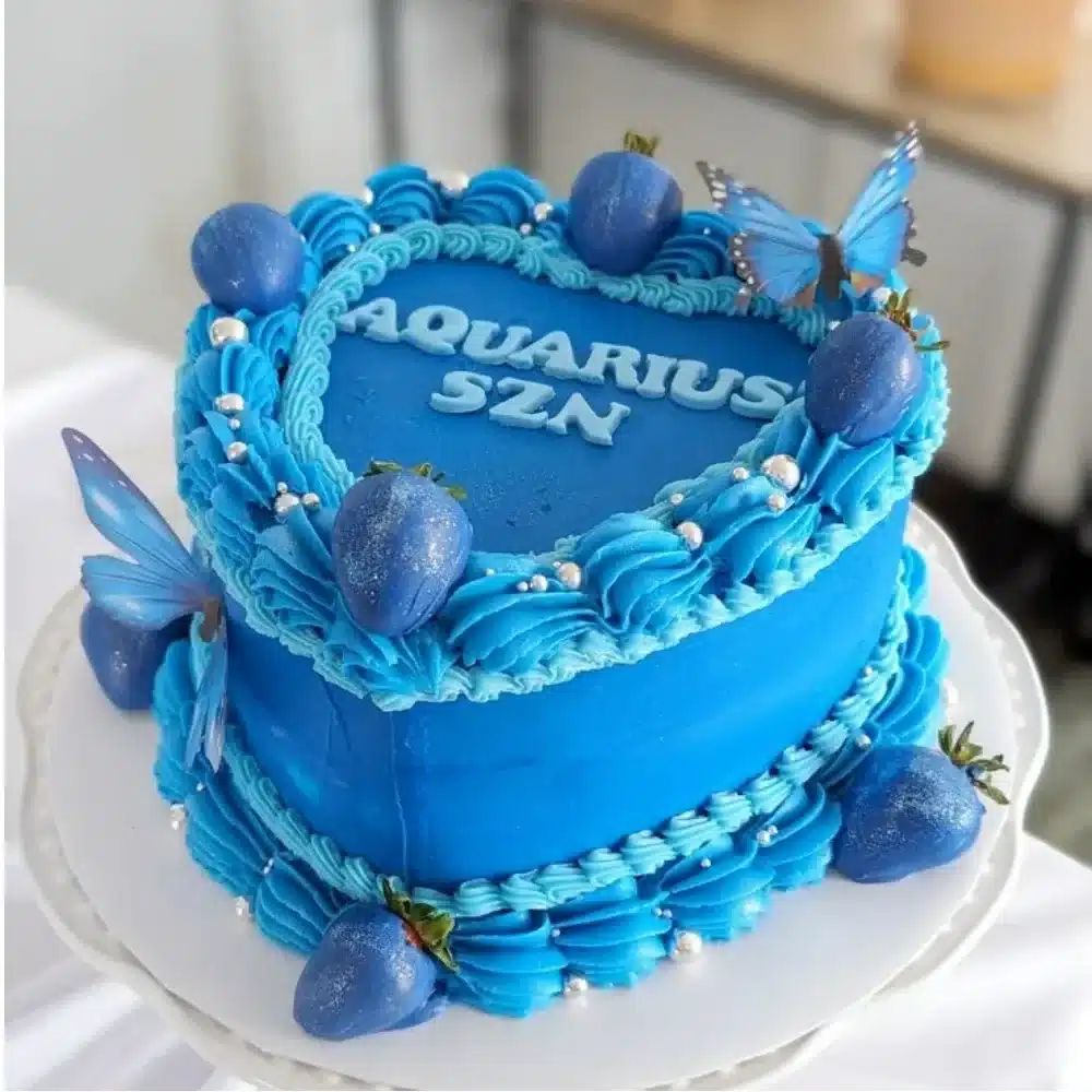 Delicious heart shaped cake decorated with fresh berries and frosting