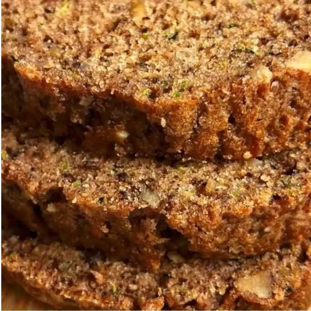 Freshly baked moist zucchini bread sliced on a wooden board