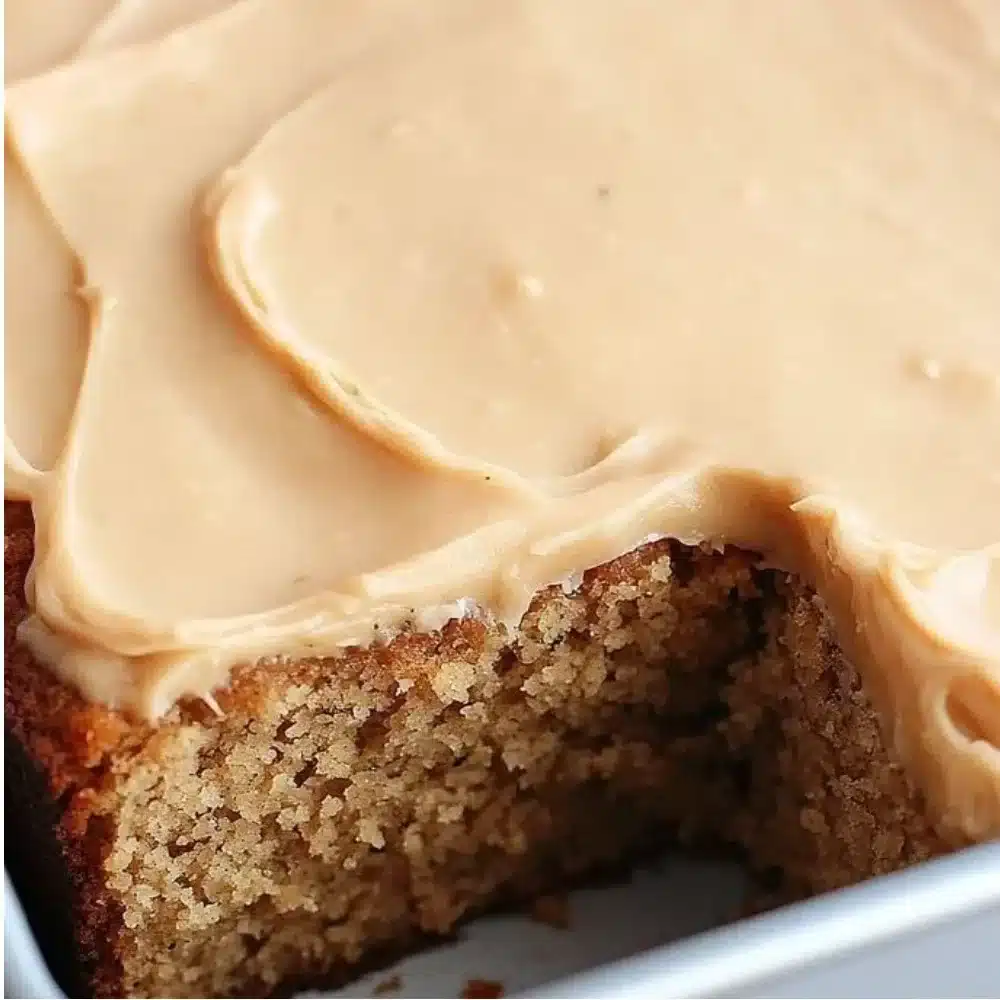 Moist zucchini cake with brown sugar icing, garnished with fresh mint leaves.