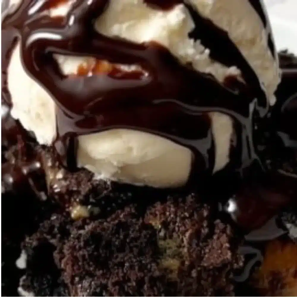 Oreo Dump Cake topped with whipped cream and chocolate drizzle