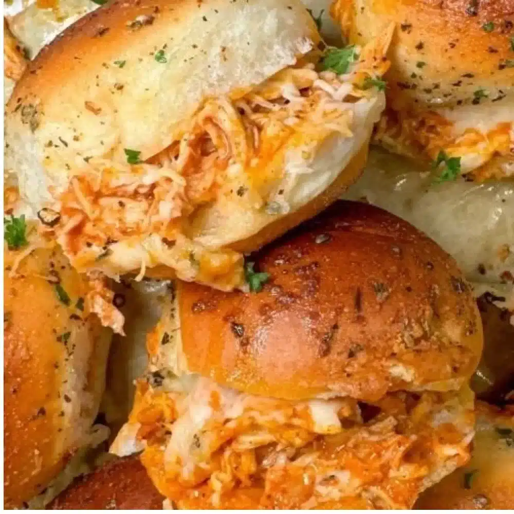 Spicy Buffalo chicken sliders served on a platter with dipping sauce.
