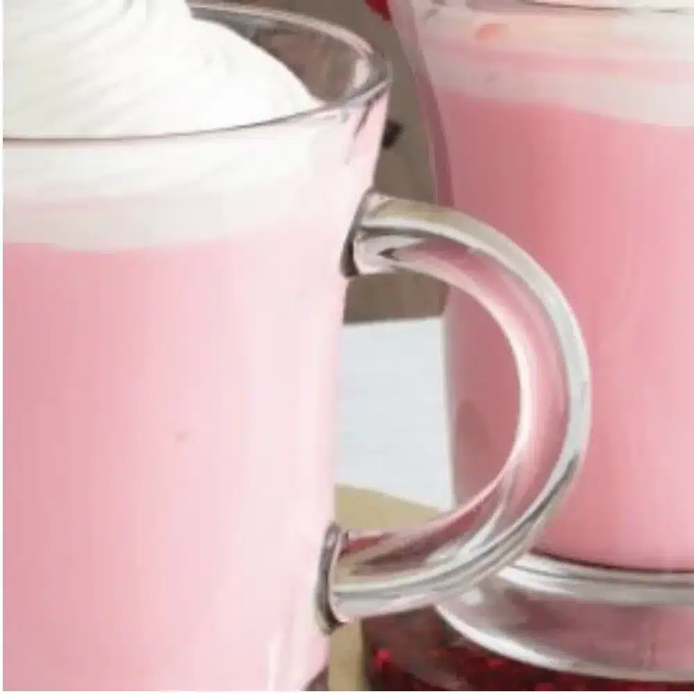 A cup of strawberry white hot chocolate topped with homemade whipped cream