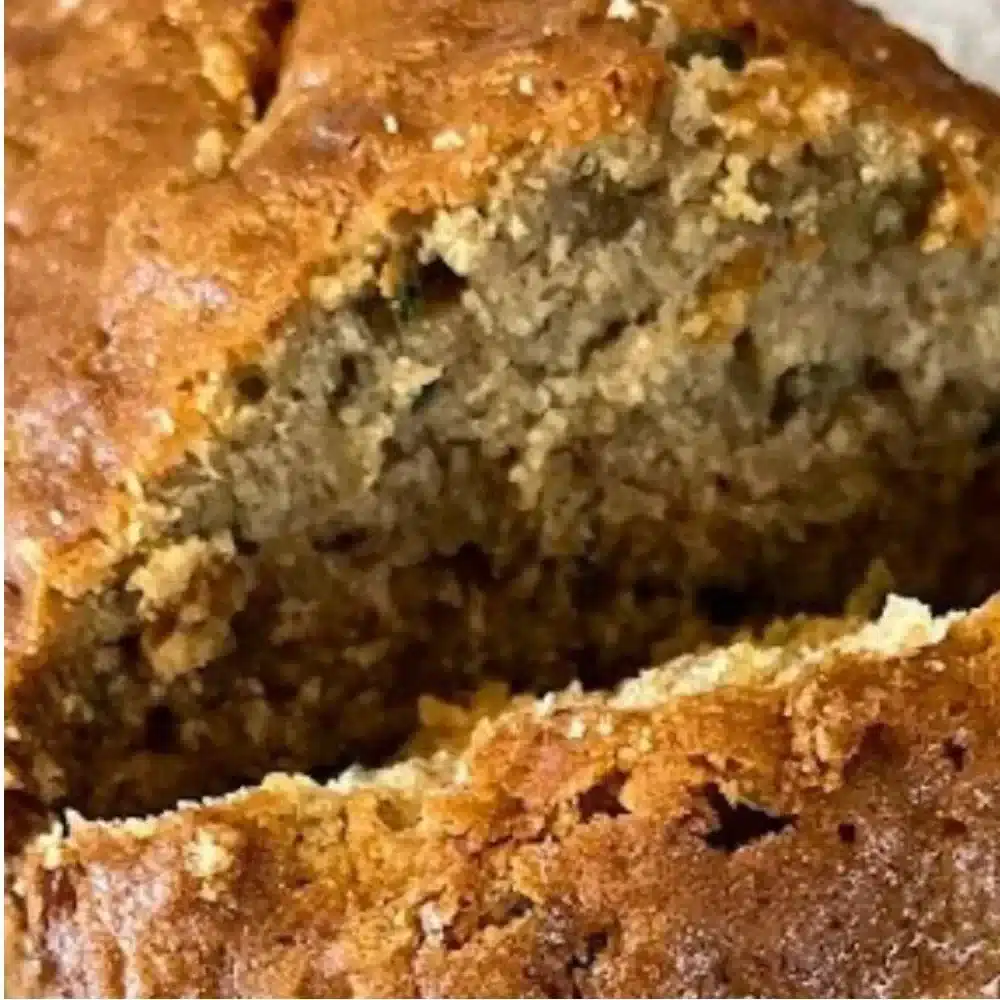Slice of homemade zucchini bread on a wooden table