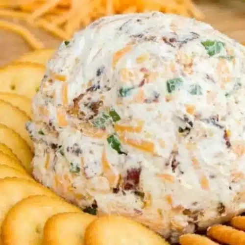 Cheddar Ranch Cheeseball on a serving platter garnished with herbs