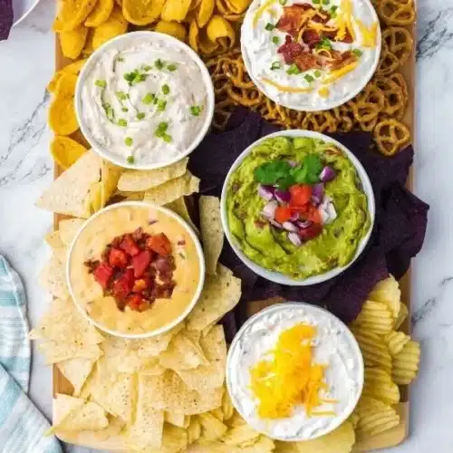Chips and dip charcuterie board with various flavors and textures