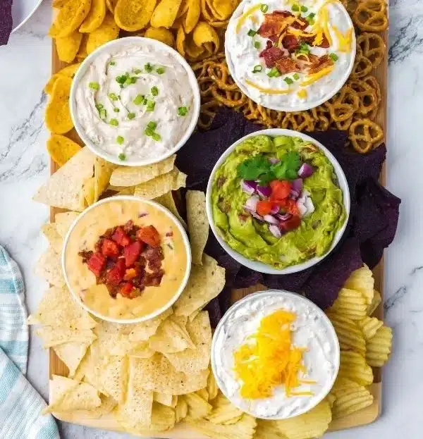 Chips and dip charcuterie board with various flavors and textures