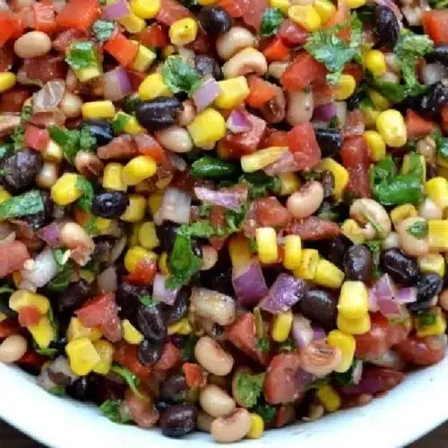 A bowl of colorful Cowboy Caviar salad with beans and vegetables
