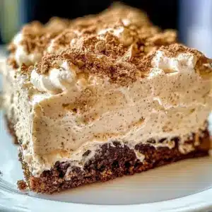 Delicious Irish Cream Poke Cake served with whipped cream and chocolate shavings.