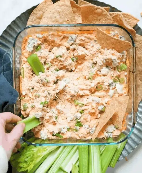Healthier Buffalo Chicken Dip served in a bowl with celery sticks