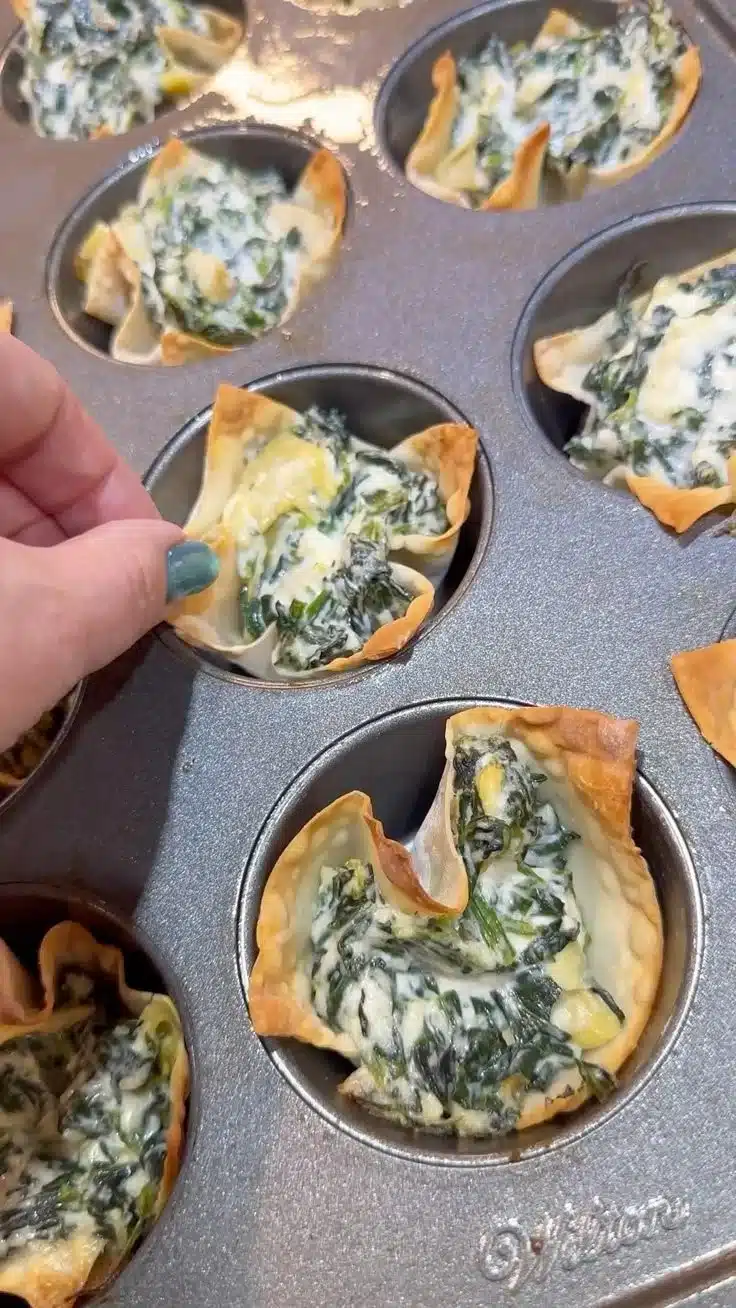 Spinach Artichoke Wonton Cups served on a plate, garnished with herbs