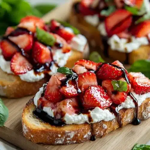 Delicious Strawberry Ricotta Bruschetta topped with fresh strawberries and basil