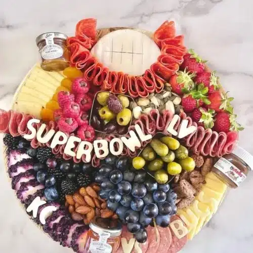 Delicious Super Bowl charcuterie board featuring meats, cheeses, and snacks.