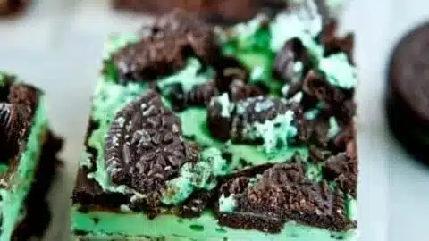 Triple layer fudgy mint Oreo brownies topped with mint cream and crushed Oreos